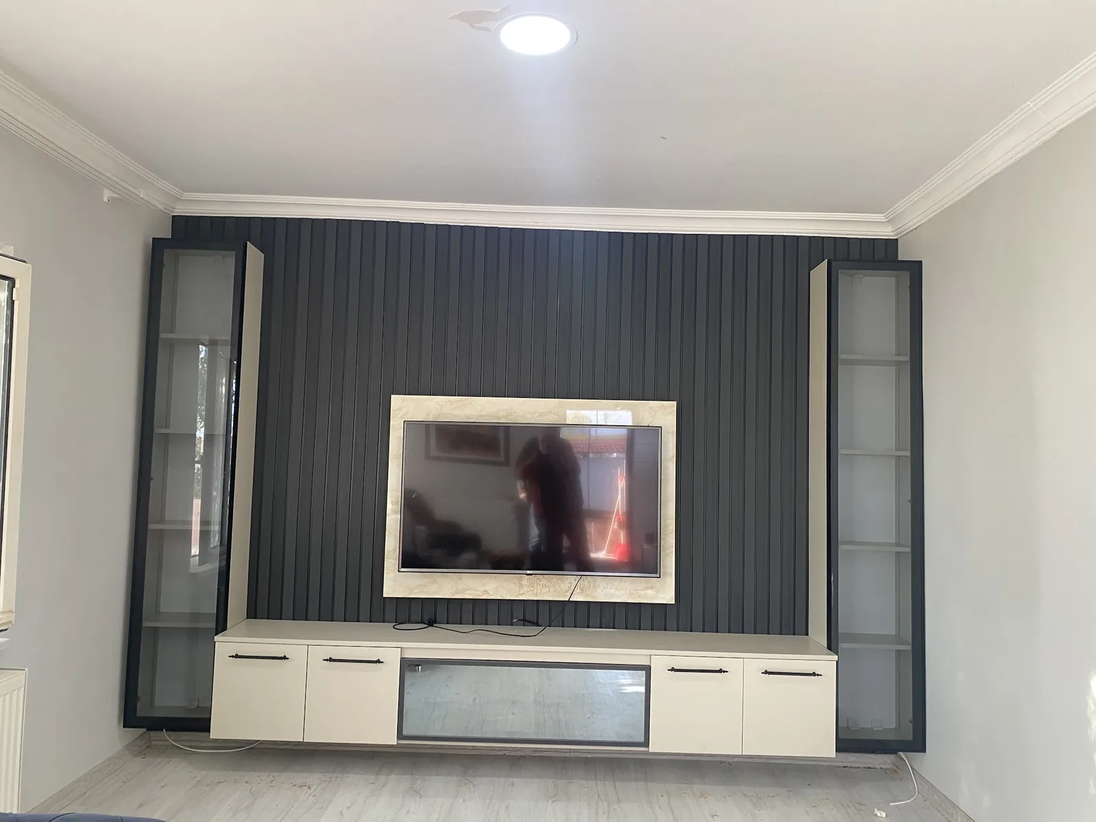 Edirne'de koyu çıta panel arka duvarlı, iki yanda cam vitrinli özel üretim TV ünitesi